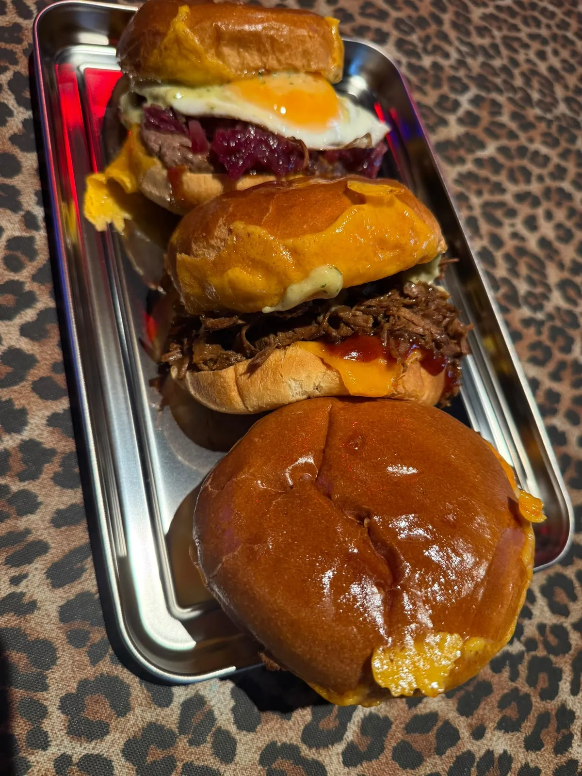 Trois burgers alignés sur le tapis léopard